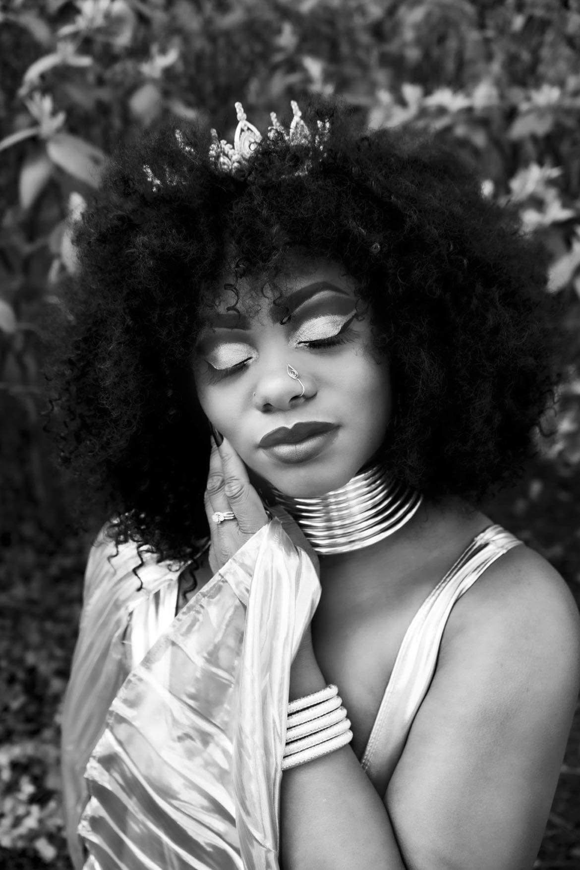 Close up of Black woman with a fro classy and elegantly touching her cheek softly. Boudoir Image in Black and white. Hinton Imagery