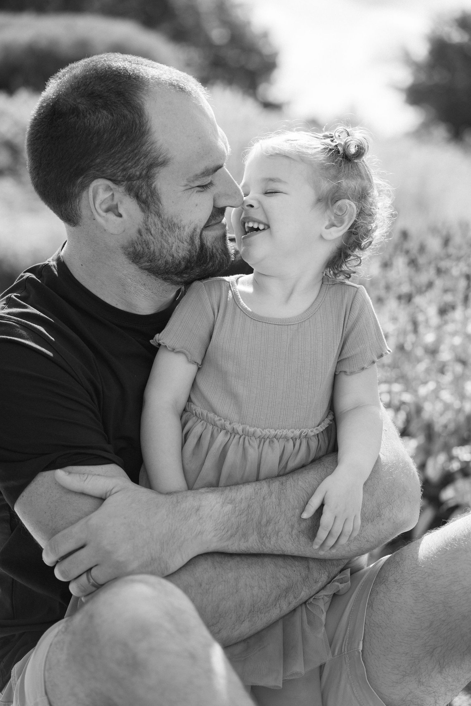 Black and white series of tender moments between parent and child in natural outdoor setting.