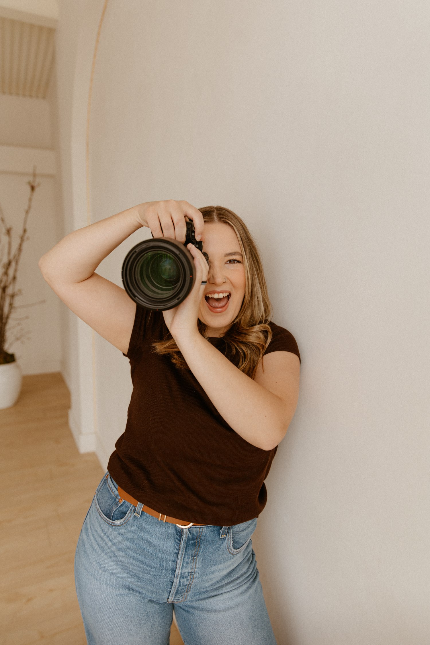 Playful lifestyle photos of someone using a camera lens in a bright indoor setting.