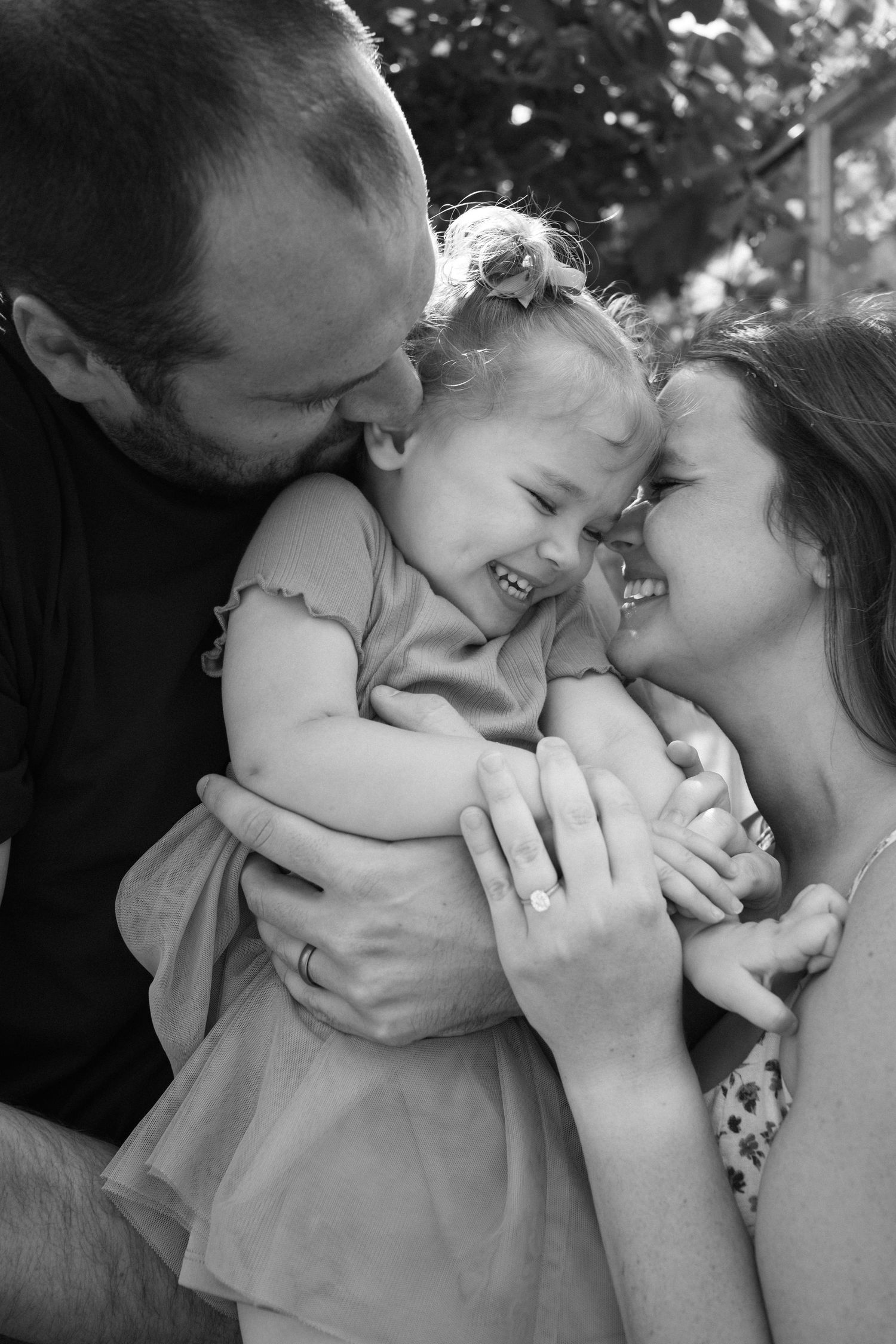 An intimate black and white family portrait showing tender moments of affection.