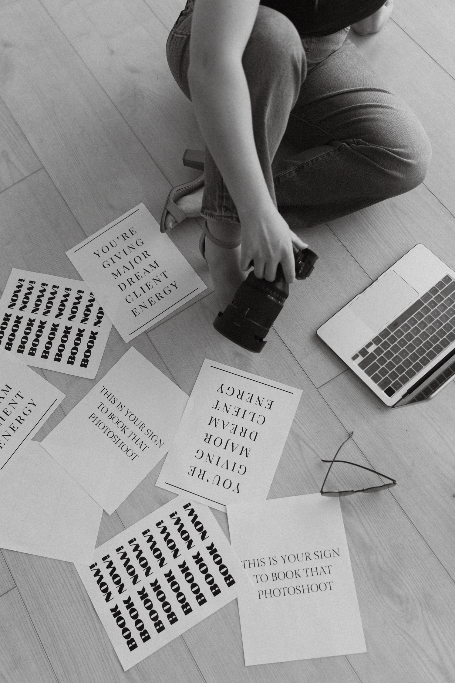Overhead view of papers and documents scattered on light wooden floor during planning session.