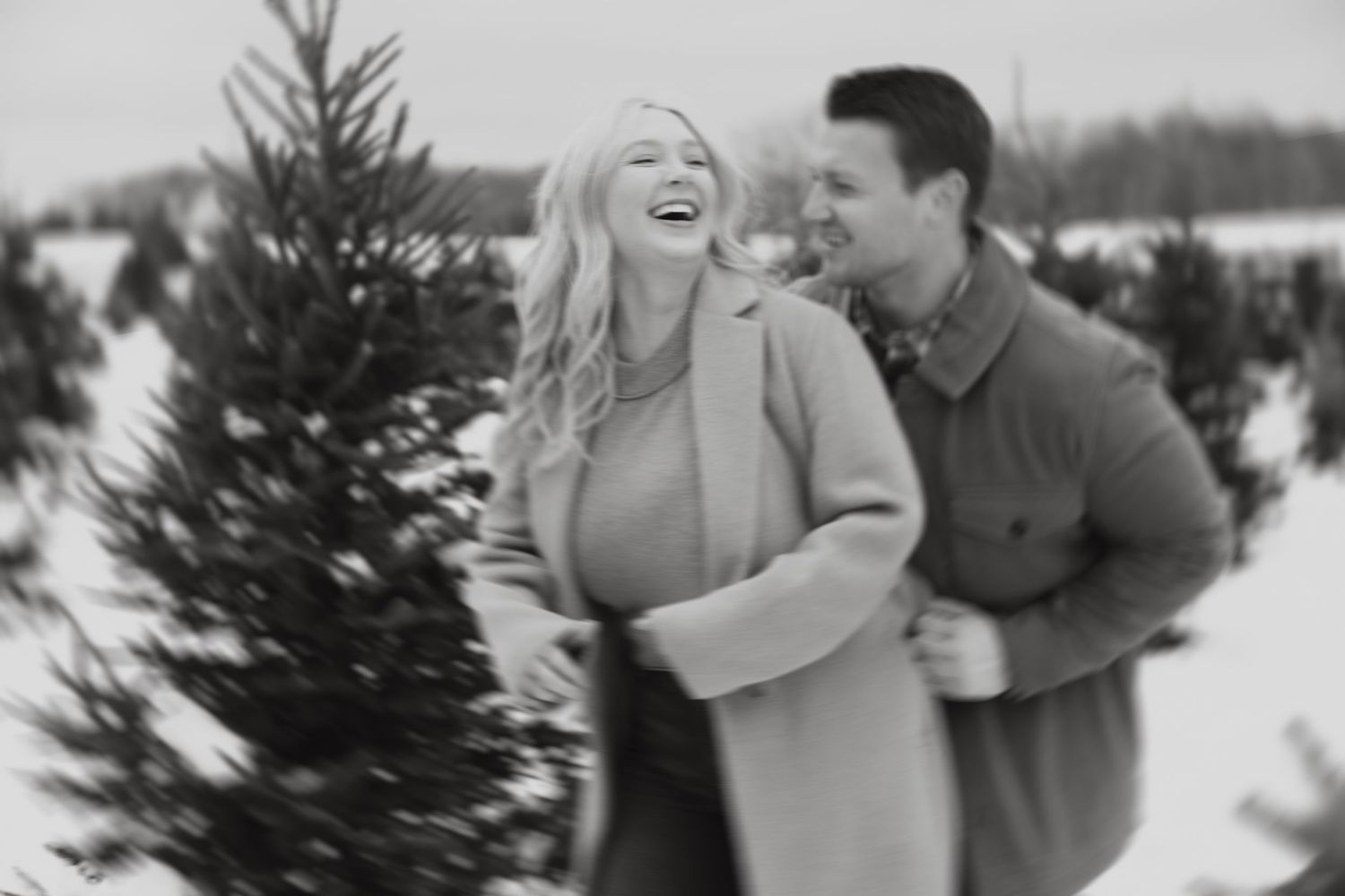 Winter engagement photo session in the snow with evergreen trees.