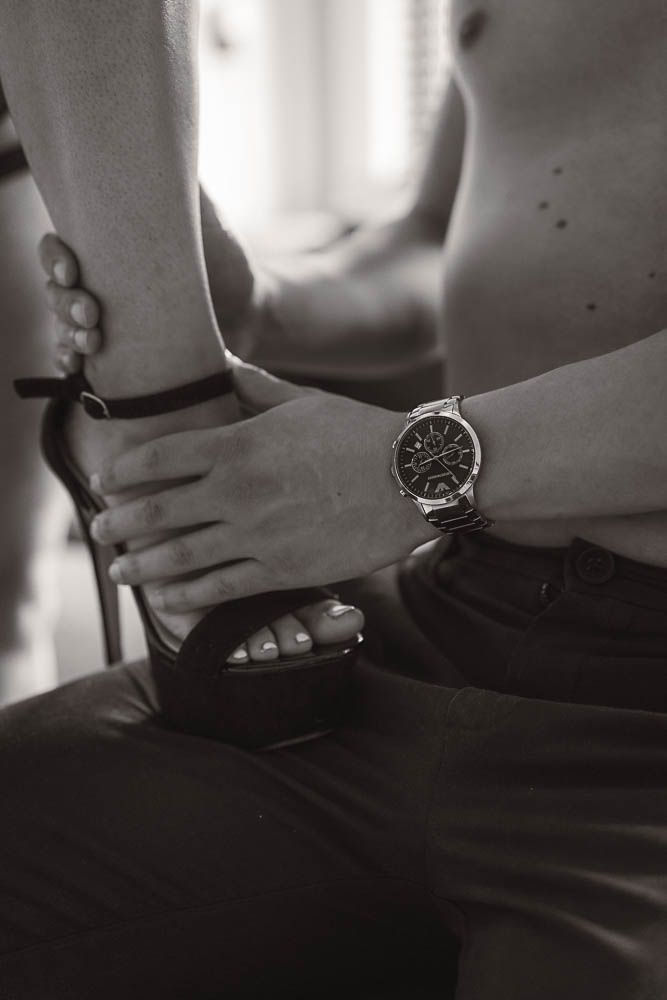 Black and white torso shots with wristwatch in dramatic window lighting.