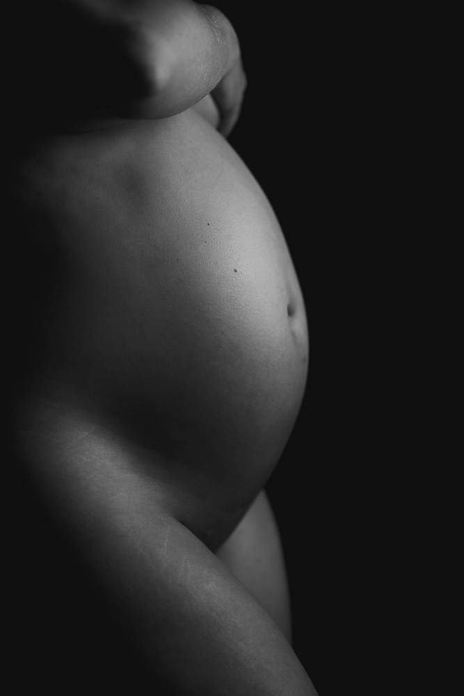 Minimalist black and white photography capturing the profile of pregnancy progression.