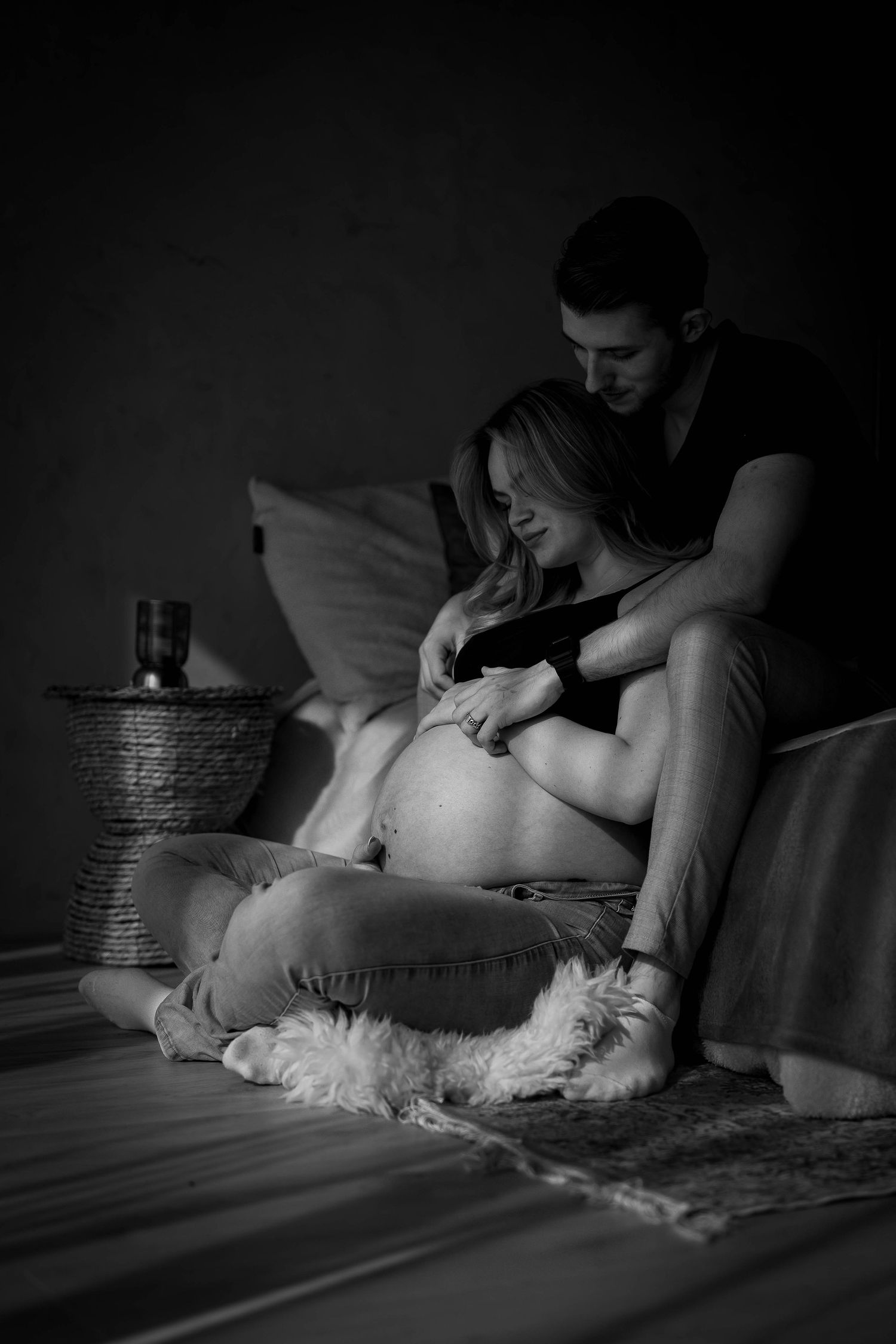 Black and white maternity session with soft lighting.