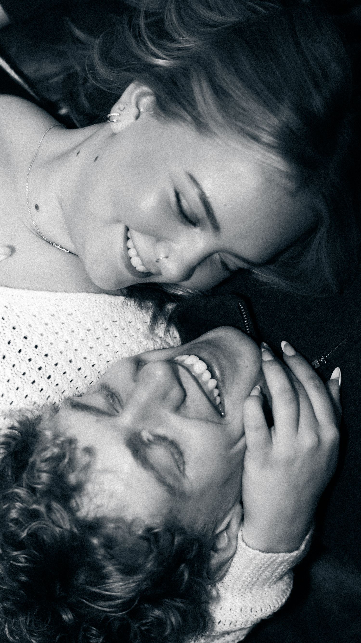 Black and white photo of two laughing women sharing a joyful moment together.