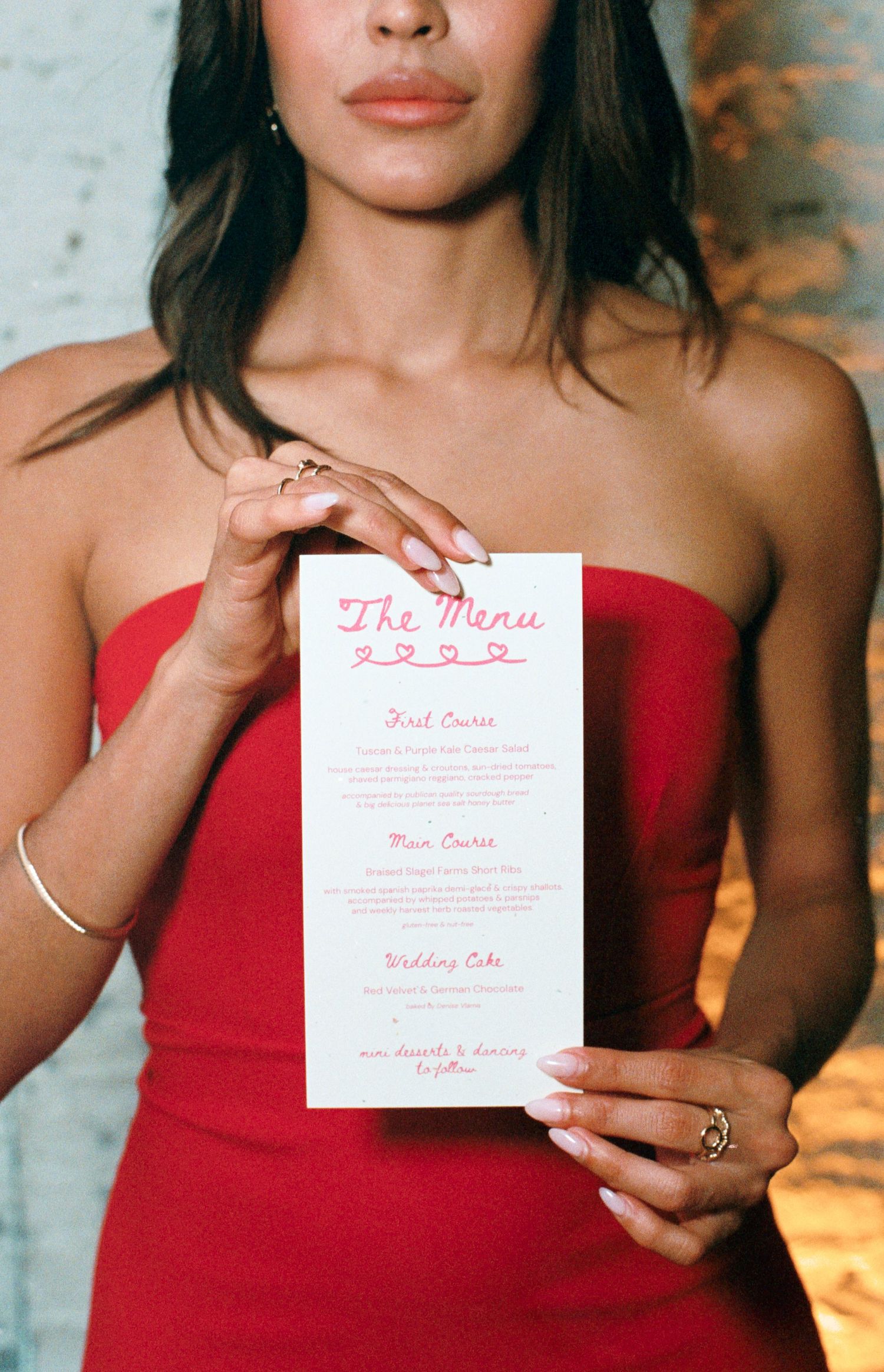 Bridesmaid holding a white and pink custom-made menu card at wedding reception in Chicago
