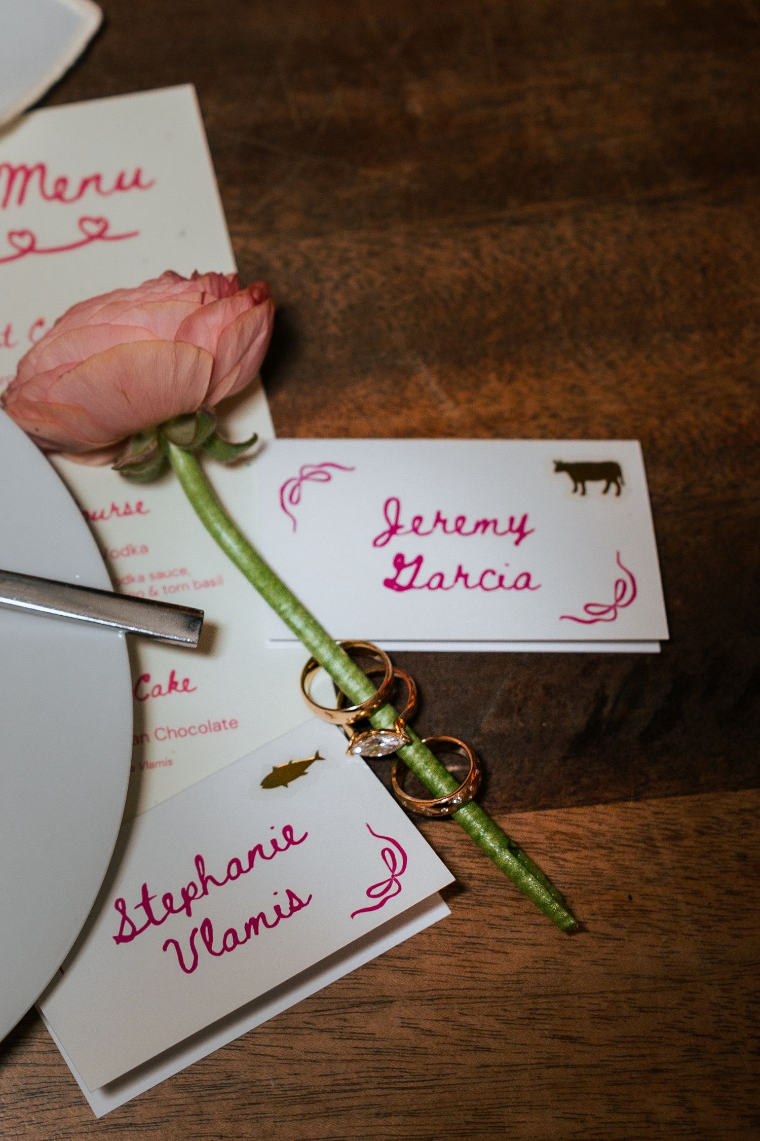 White and pink custom wedding escort cards with flower and wedding rings