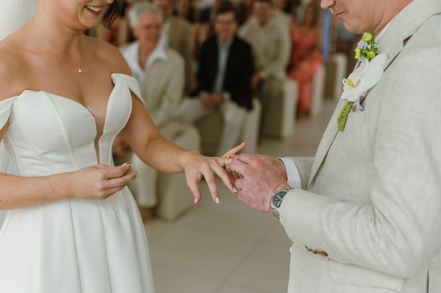 Close-up shot of wedding ring exchange during ceremony.