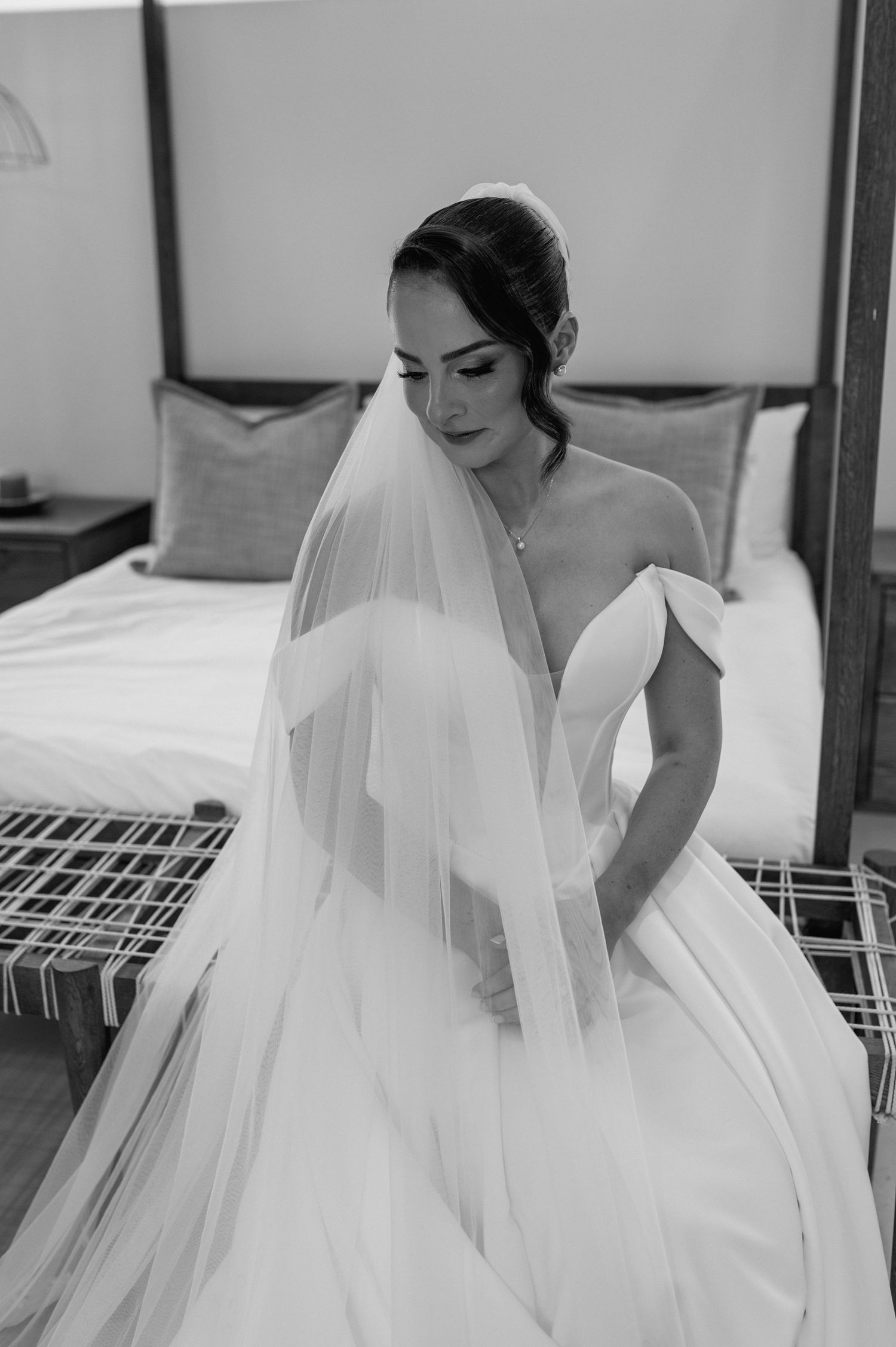 Elegant bridal portrait in black and white showing off wedding gown and veil details.