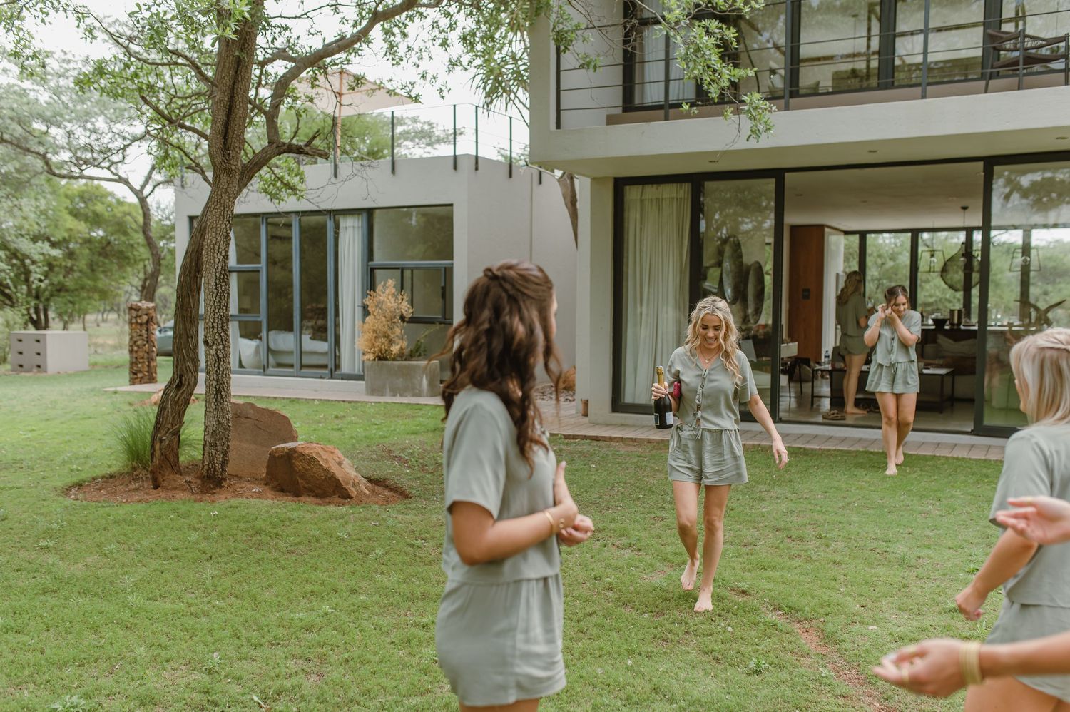 Modern white house exterior with large windows and green landscaping.