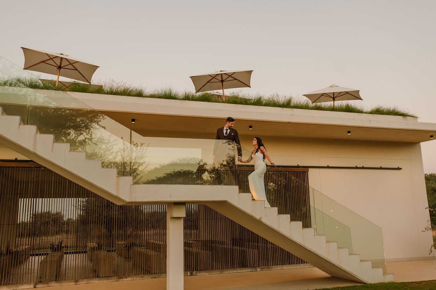 A couple poses on modern architectural stairs with geometric design elements.