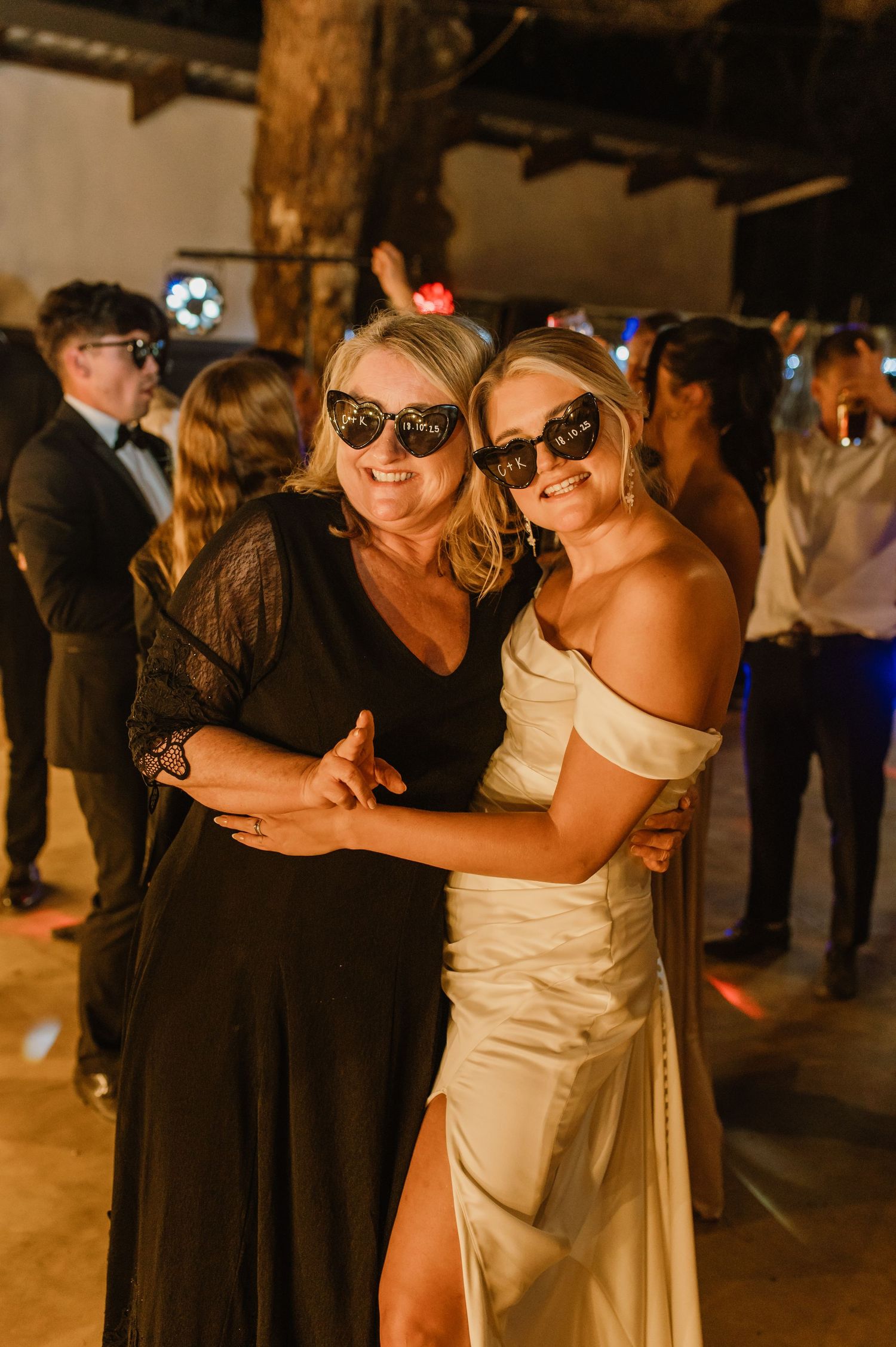 Wedding guests in formal attire dancing and celebrating at an evening reception.