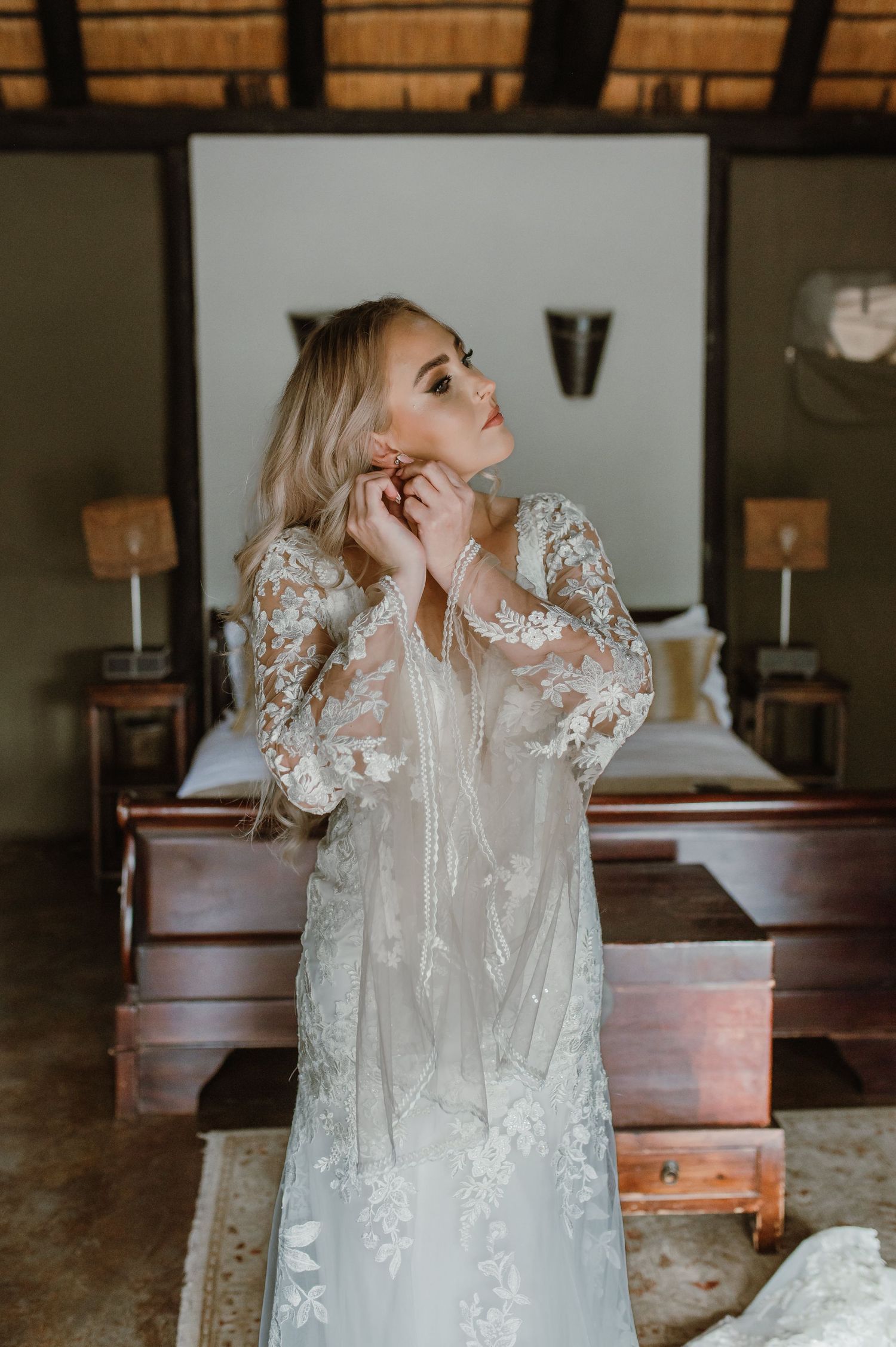Ethereal wedding gown with sheer overlay and floral embellishments in natural light.