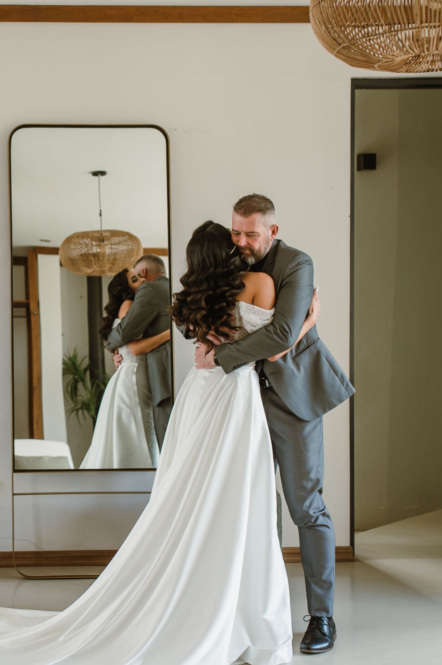 A romantic first look moment between newlyweds with the bride in white and groom in grey.