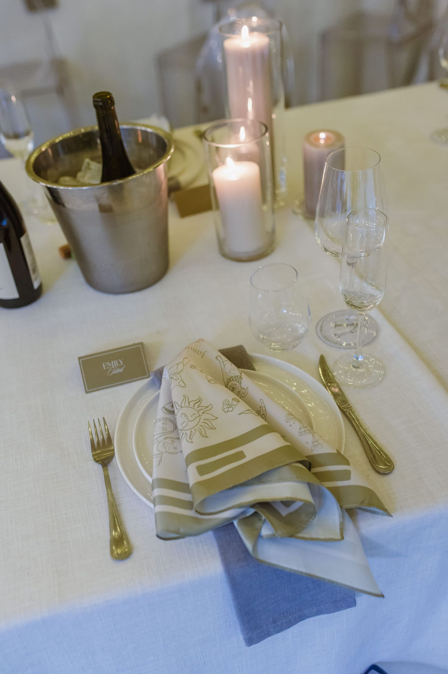 Elegant table setting with candles, wine glasses, and folded napkins at a formal event.