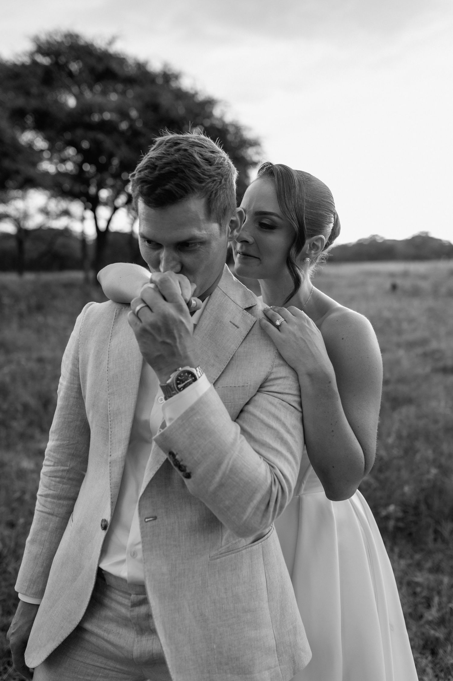 A black and white photo sequence captures a tender moment between newlyweds in a natural setting.