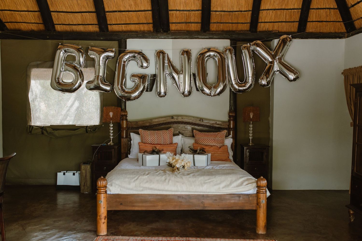 Rustic wooden beds with thatched roof decor create a cozy lodge atmosphere.