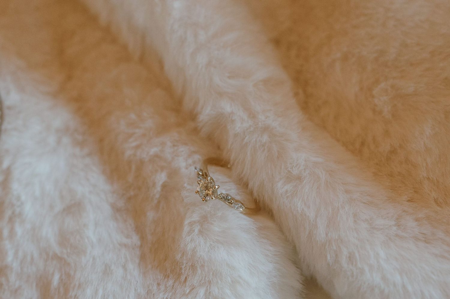Close-up texture of plush cream-colored fabric with soft lighting.