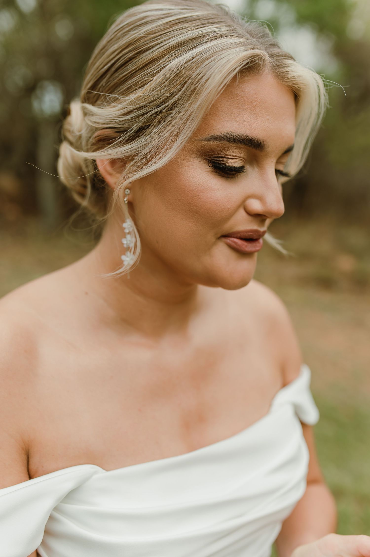 Close-up bridal portrait showcasing elegant makeup and dangling earrings.