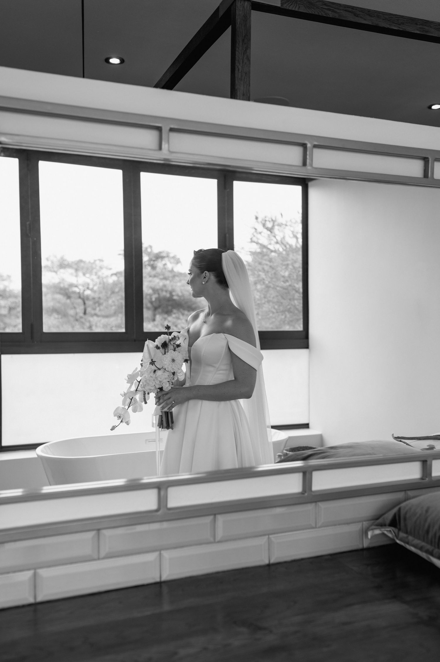 Modern interior space with large windows and white walls captured in black and white photography.