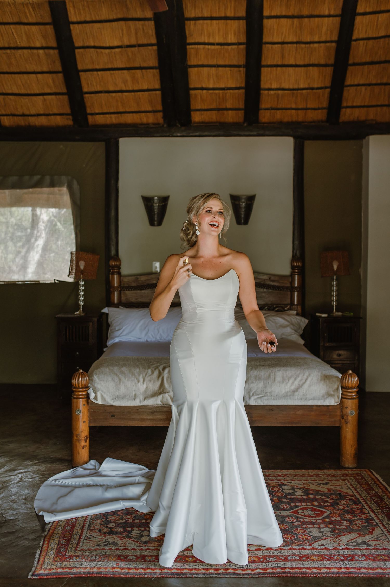 Candid wedding dress moment on patterned rug in rustic room setting.
