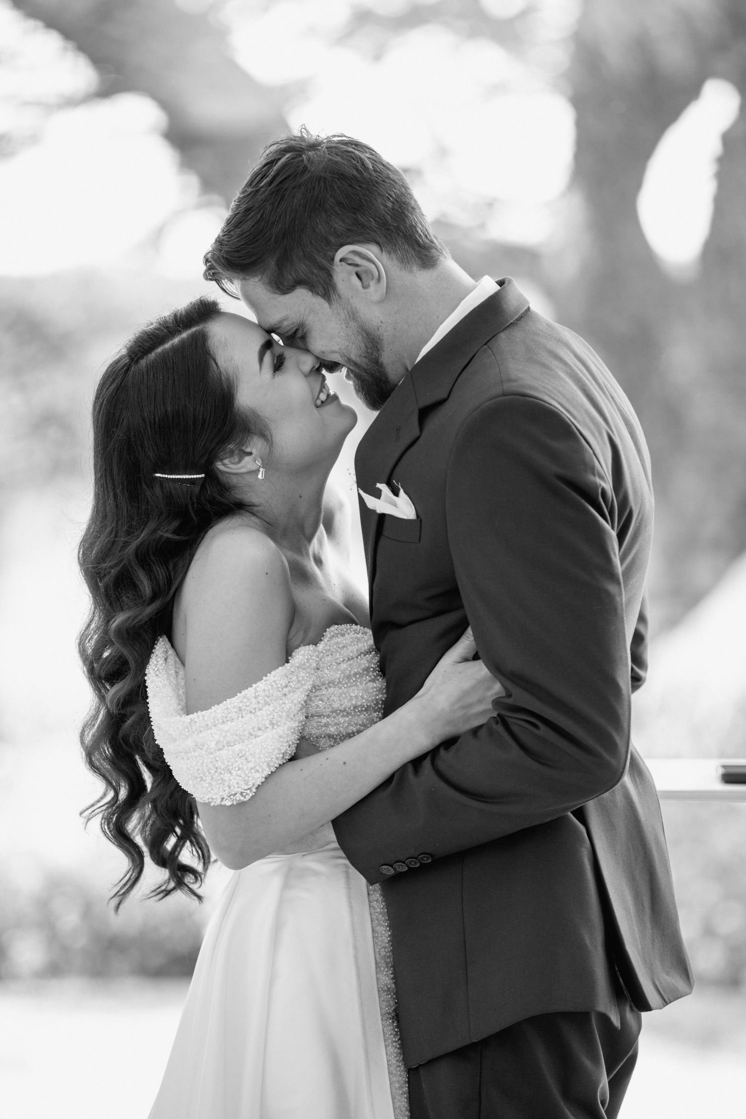 Intimate black and white portrait of newlyweds sharing tender moment.