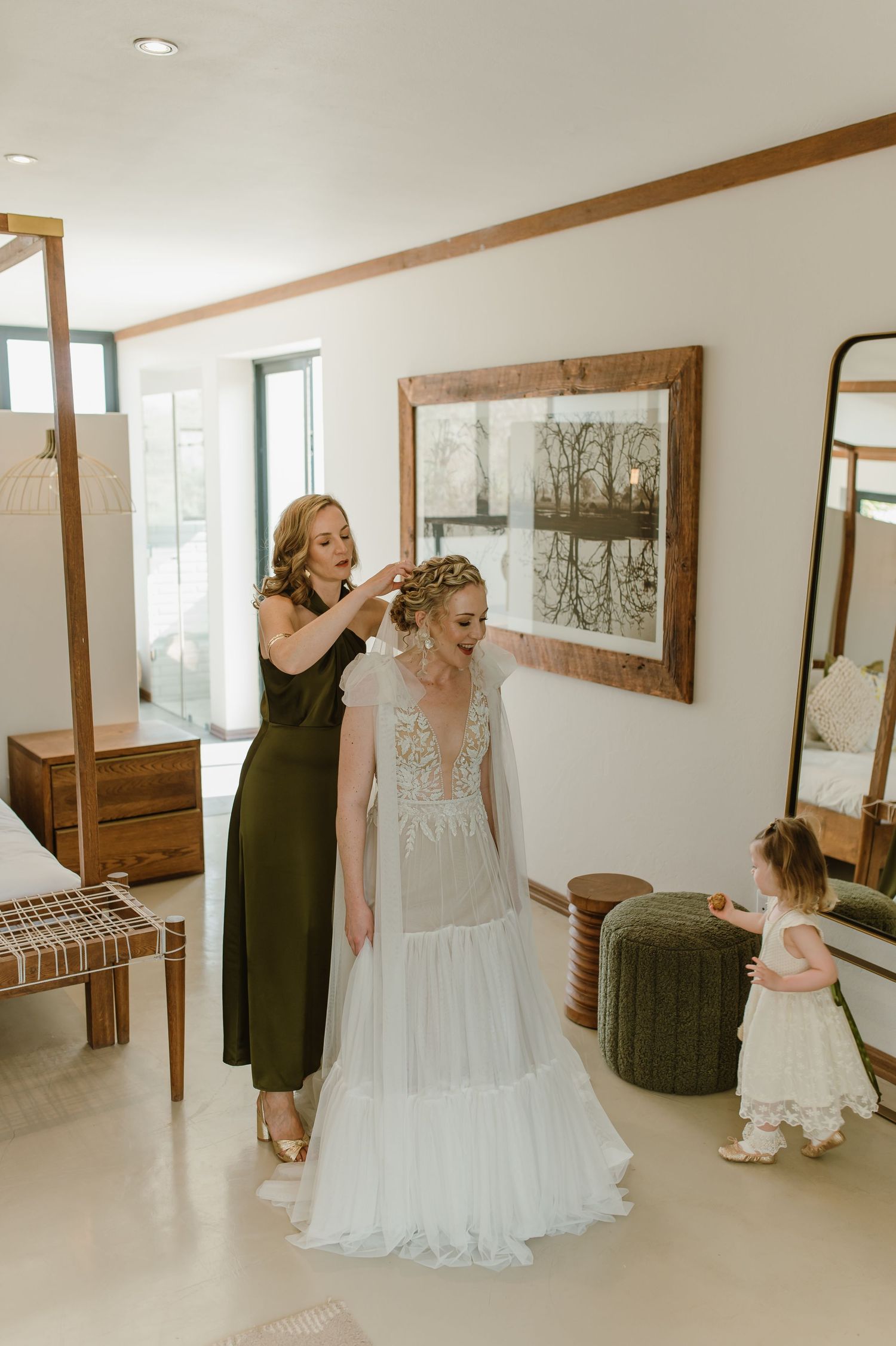 Wedding dress preparations in a minimalist room with wooden framed mirrors.