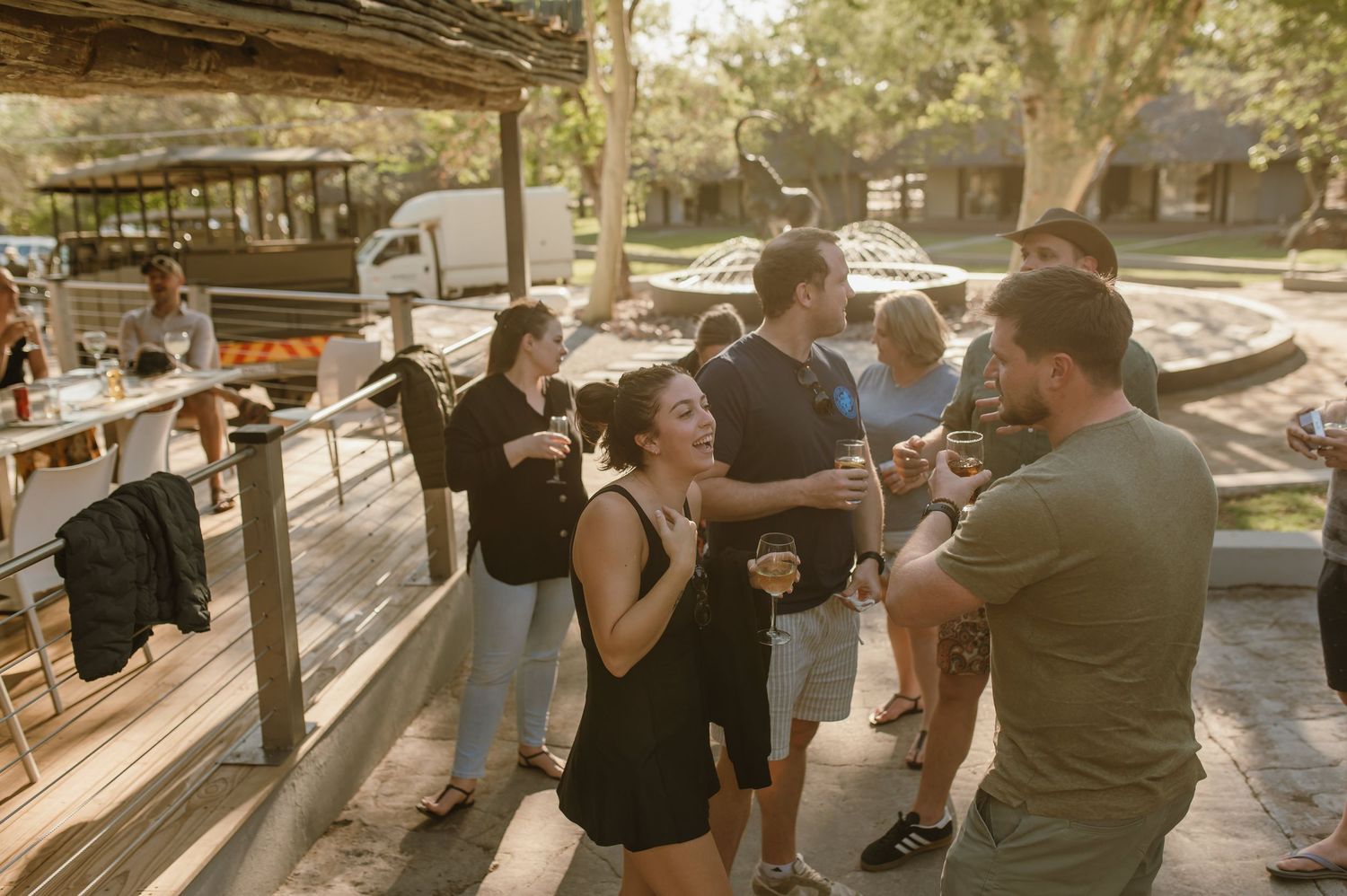 Group of people socializing in an outdoor venue during golden hour.