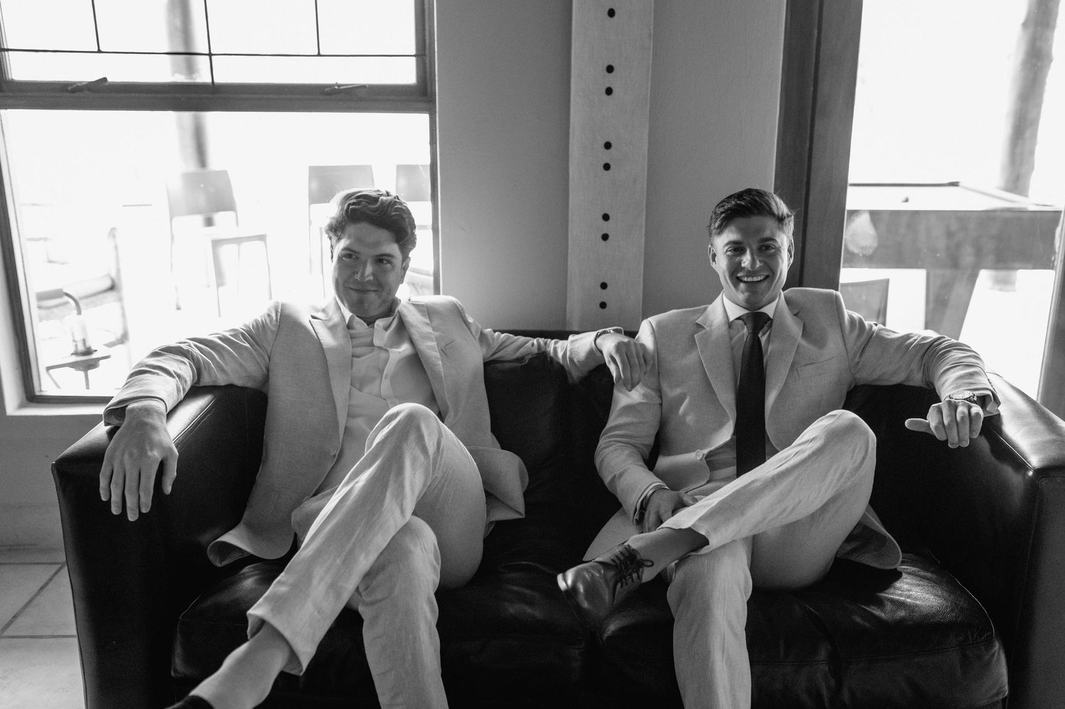 Group of men in formal attire sitting together in black and white photography.