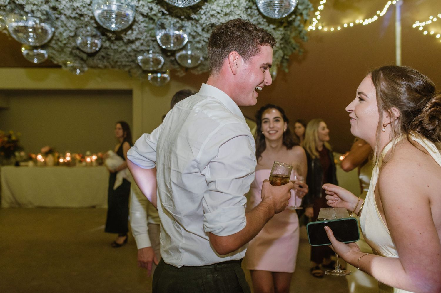 Wedding reception with string lights and disco balls creating a romantic atmosphere.