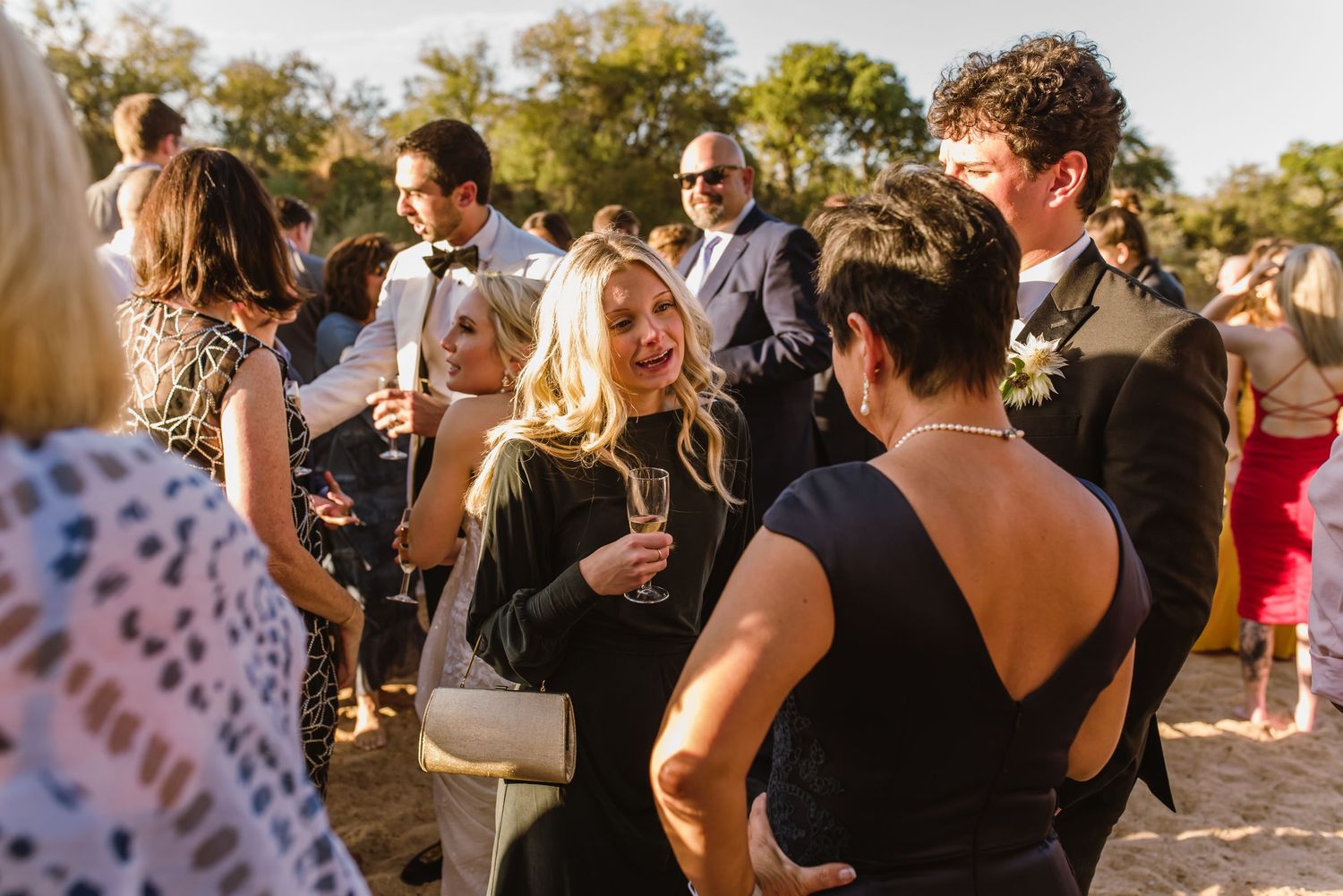 Guests enjoying drinks and conversation at a casual outdoor beach gathering.