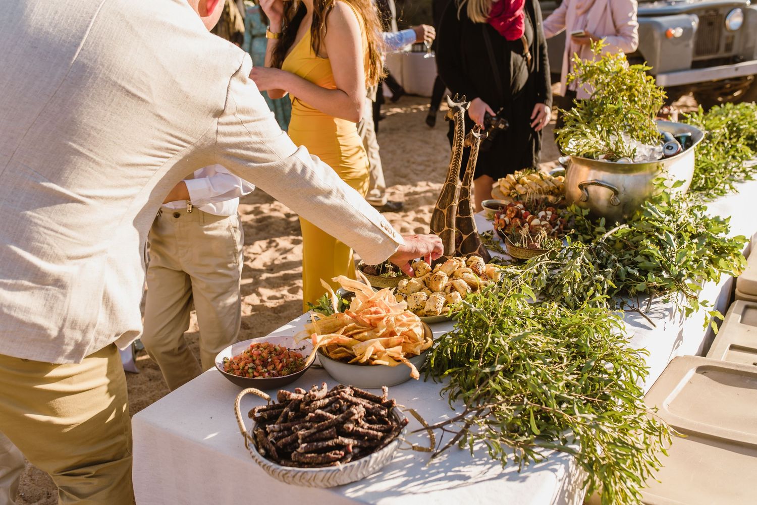 Wedding reception buffet table with rustic decorations and natural greenery.