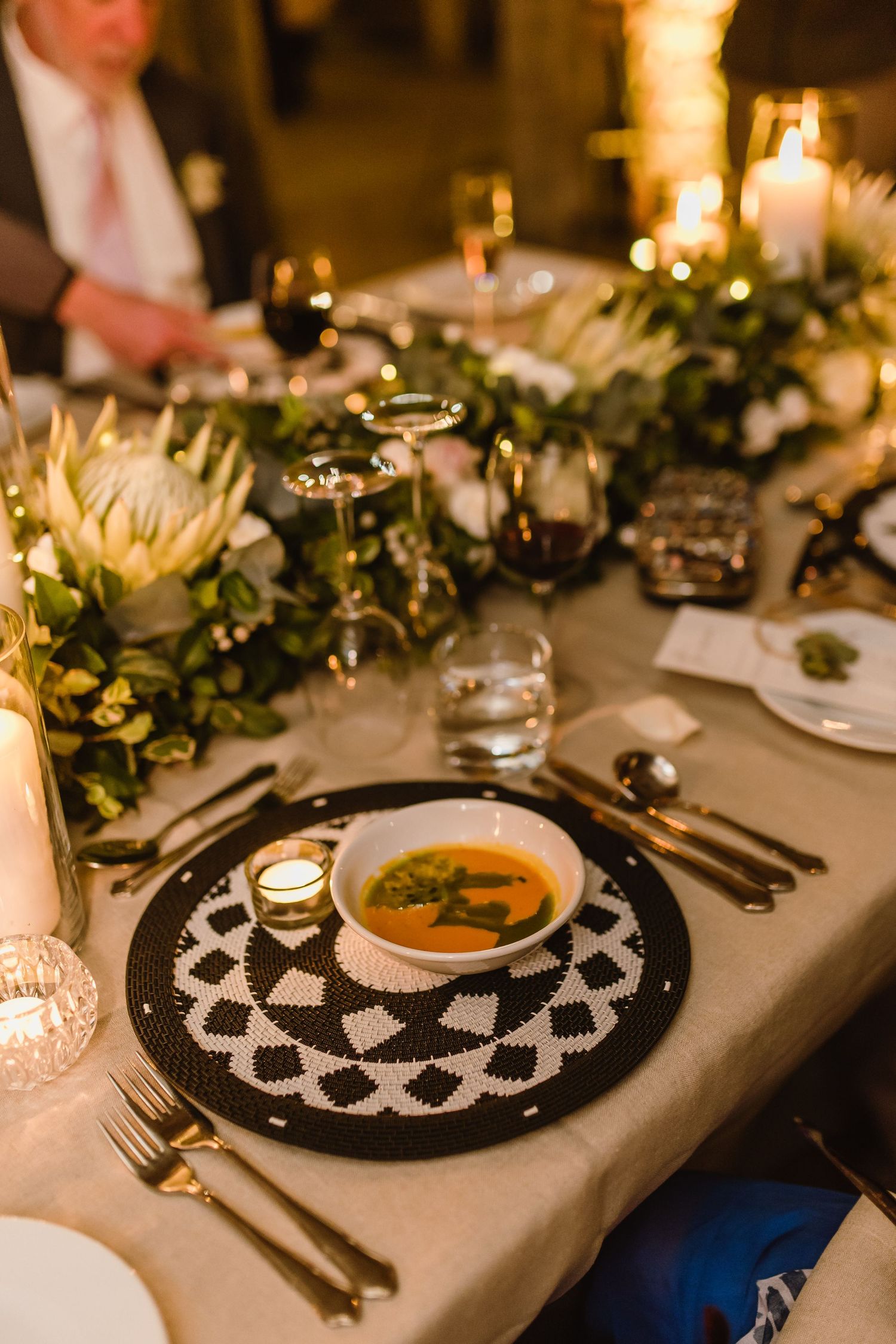 Elegant place settings with black plates and decorative doilies on white tablecloth.
