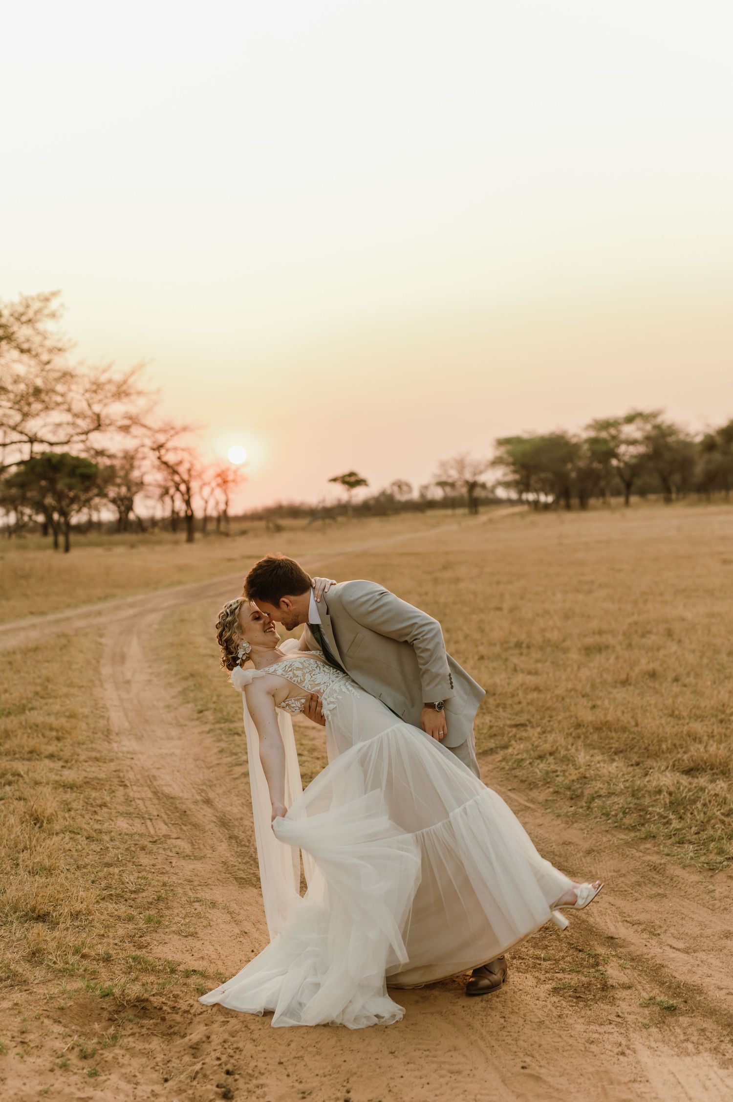 Elegant couple sharing romantic dance moves during sunset wedding photoshoot.