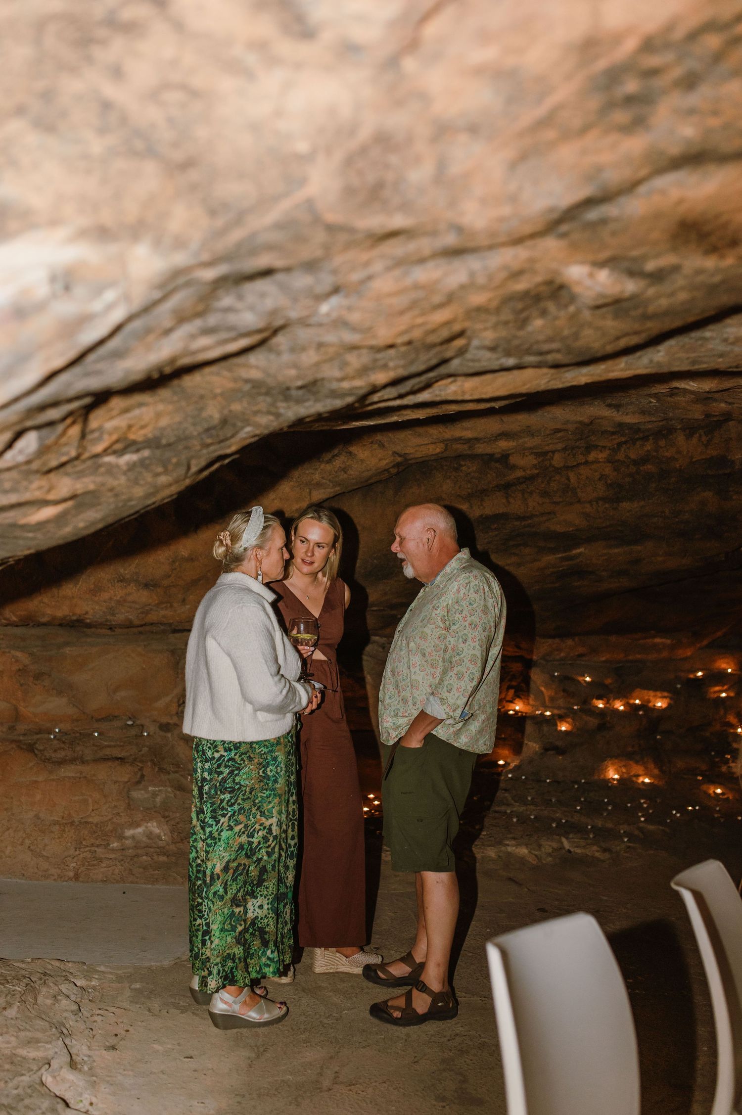 People gathered in a cave-like space with warm lighting and stone walls.