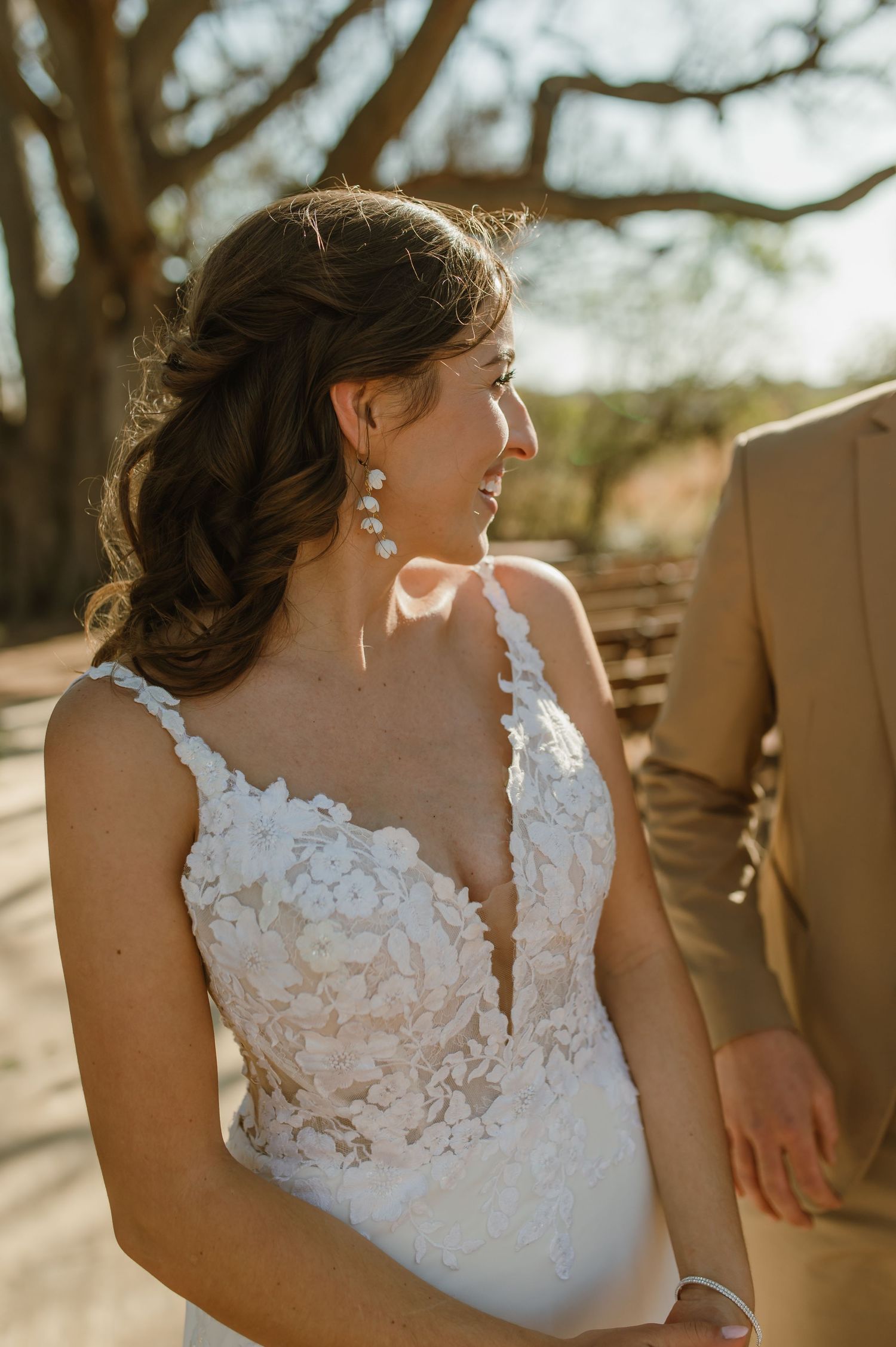 Close-up details of delicate lace wedding dress in natural sunlight.