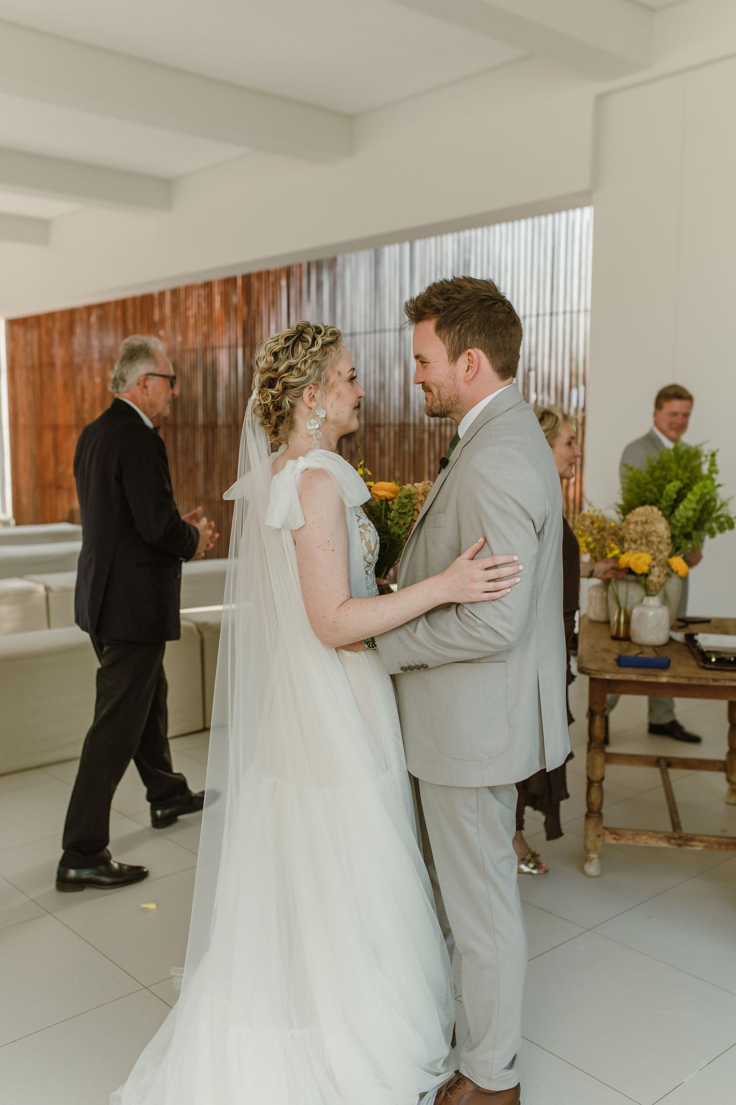 Wedding couple sharing a private first look moment in a bright modern indoor space.