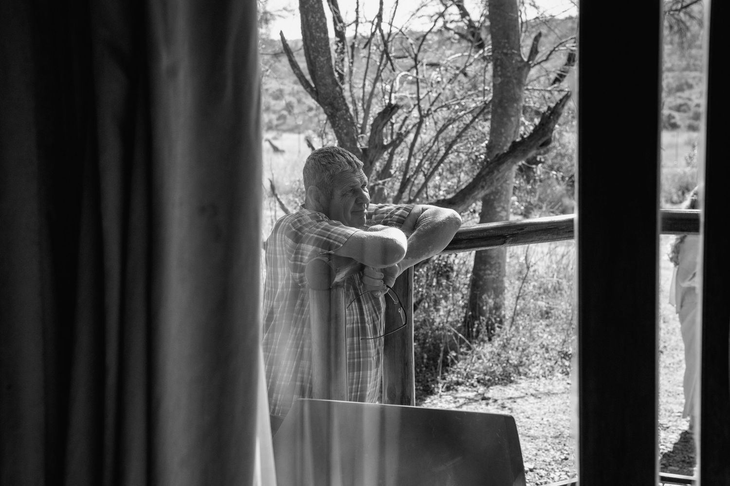 Silhouettes of people seen through window curtains in natural lighting.