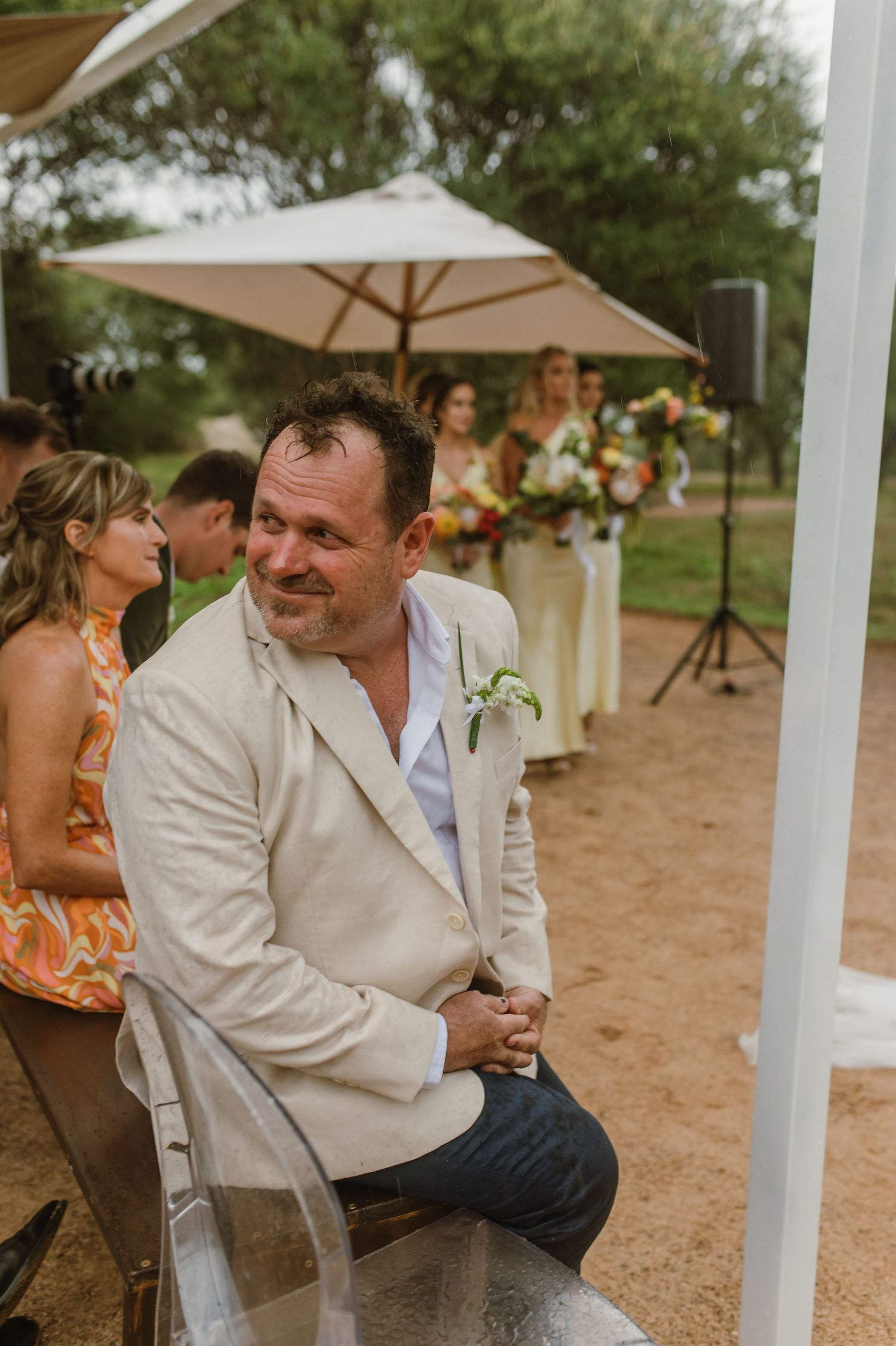 A casual outdoor wedding reception with beige umbrellas and natural desert landscape.