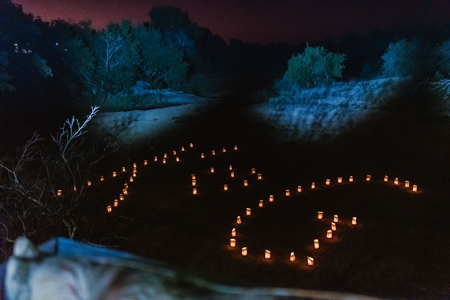 Path lit by warm glowing lanterns creating a romantic walkway at dusk.