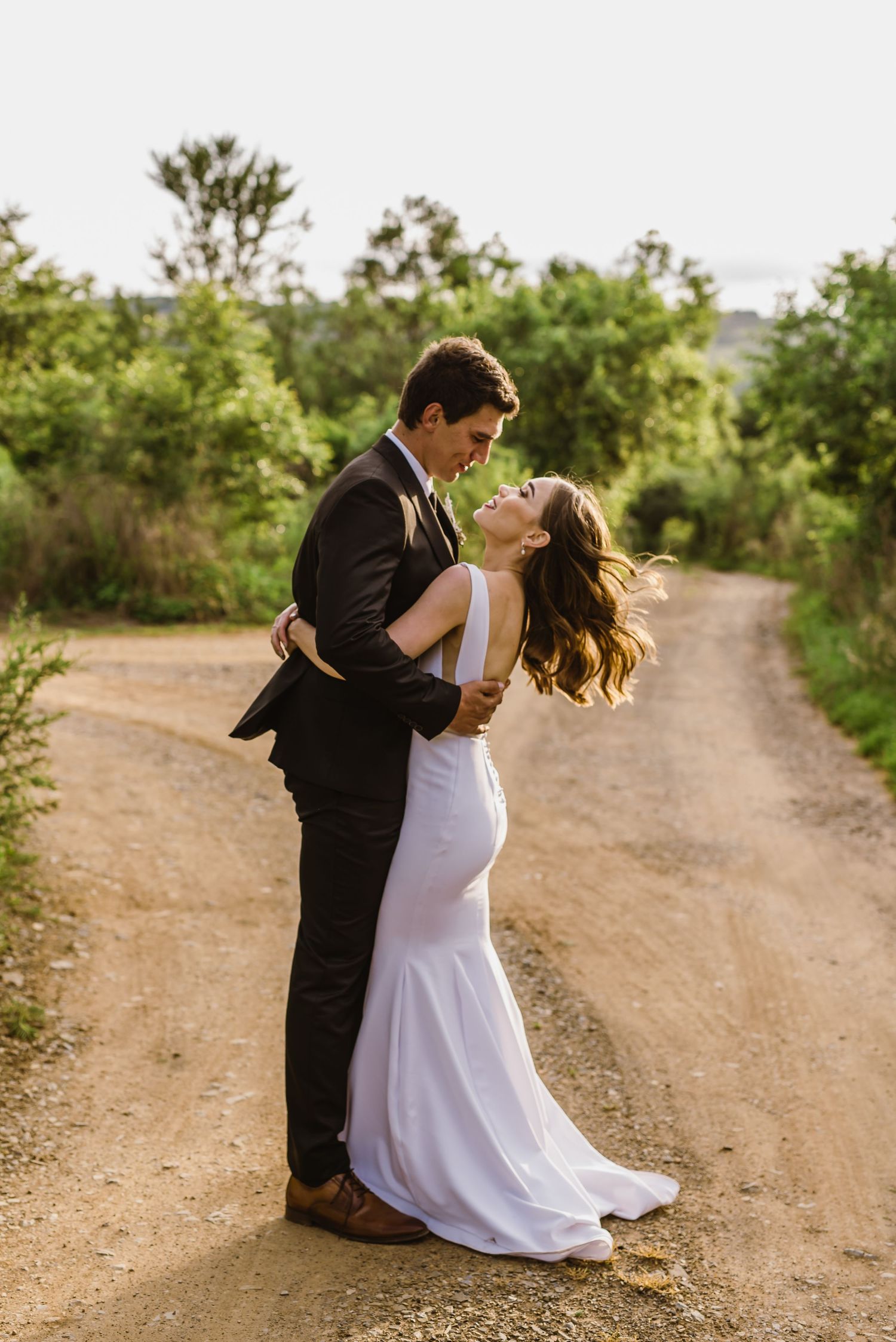 A romantic dance sequence between newlyweds on a sunlit dirt path.