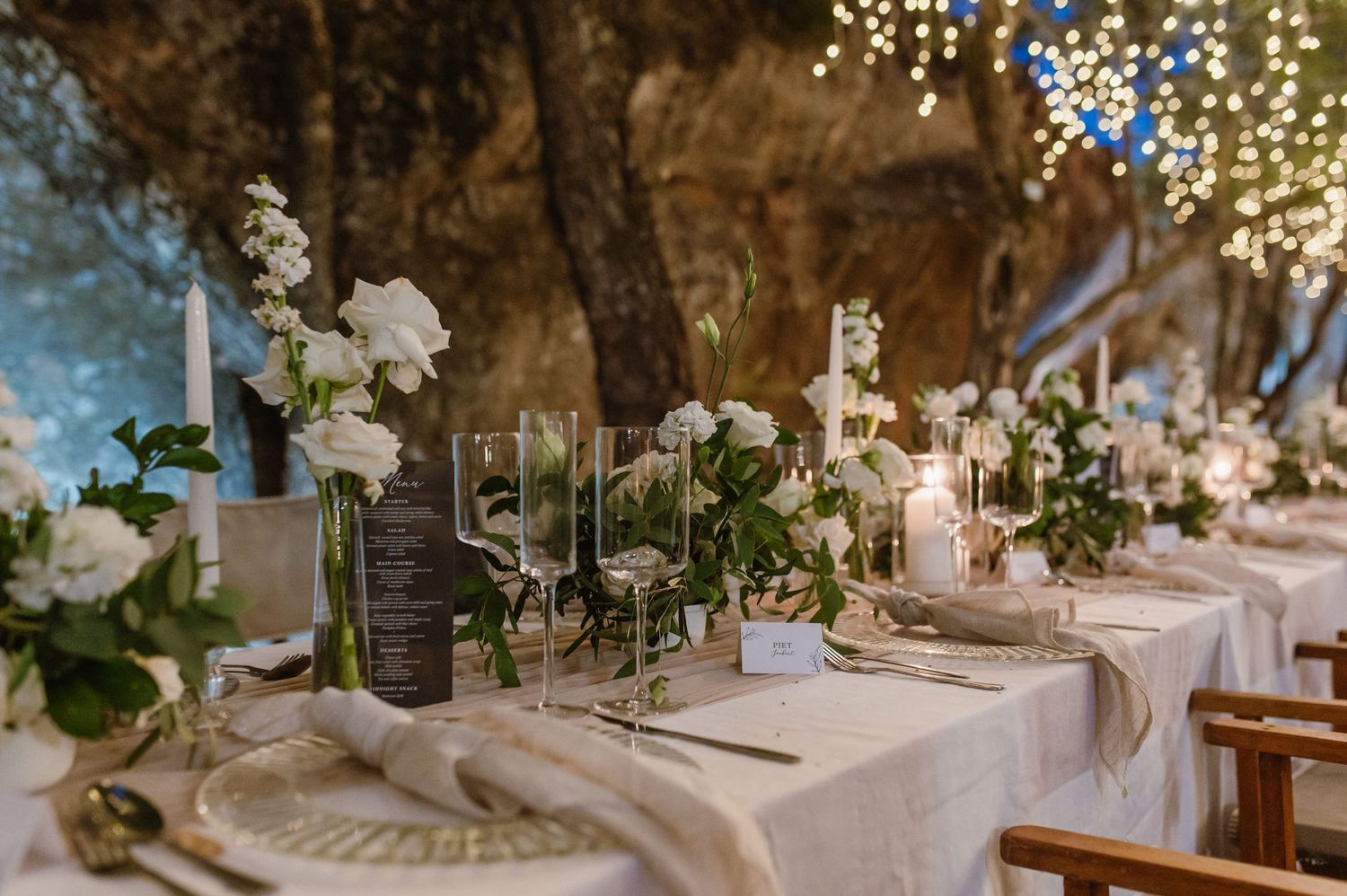 Elegant wedding reception tables decorated with white floral centerpieces and ambient lighting.