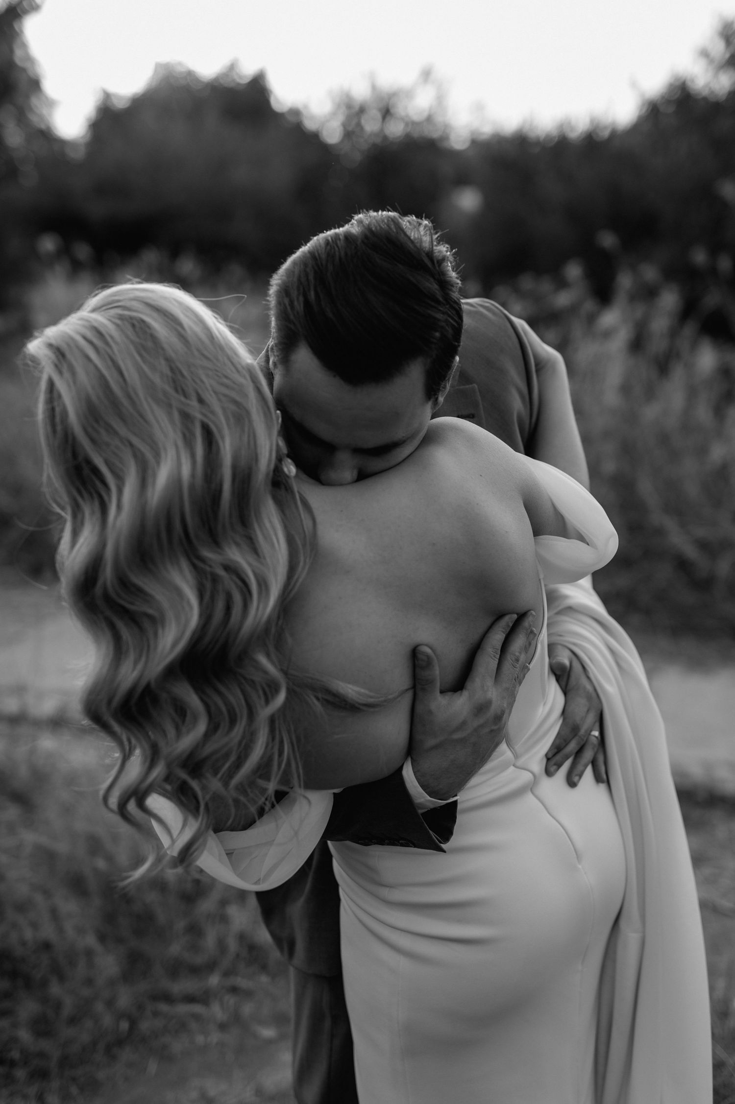 Black and white photo captures an intimate moment between a couple during their wedding shoot.
