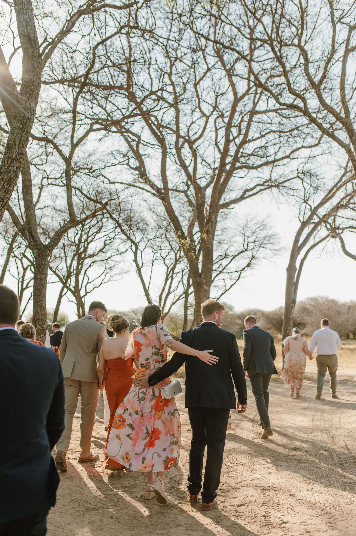 Wedding celebration under bare trees with guests watching the festivities.
