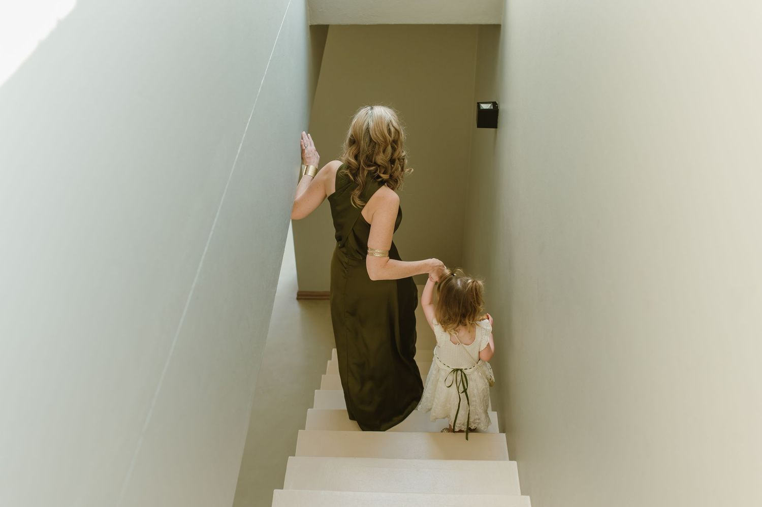 People ascending white stairs during wedding preparations.