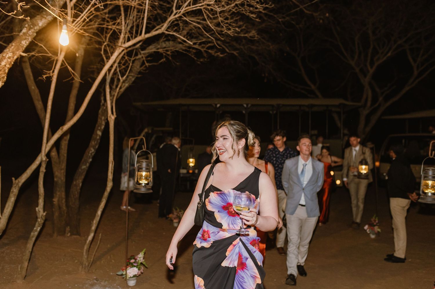 Wedding guests dancing and celebrating at a nighttime outdoor reception.