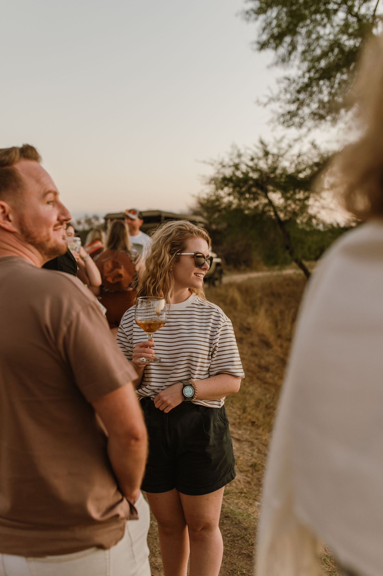 Friends socializing at an outdoor gathering during golden hour.