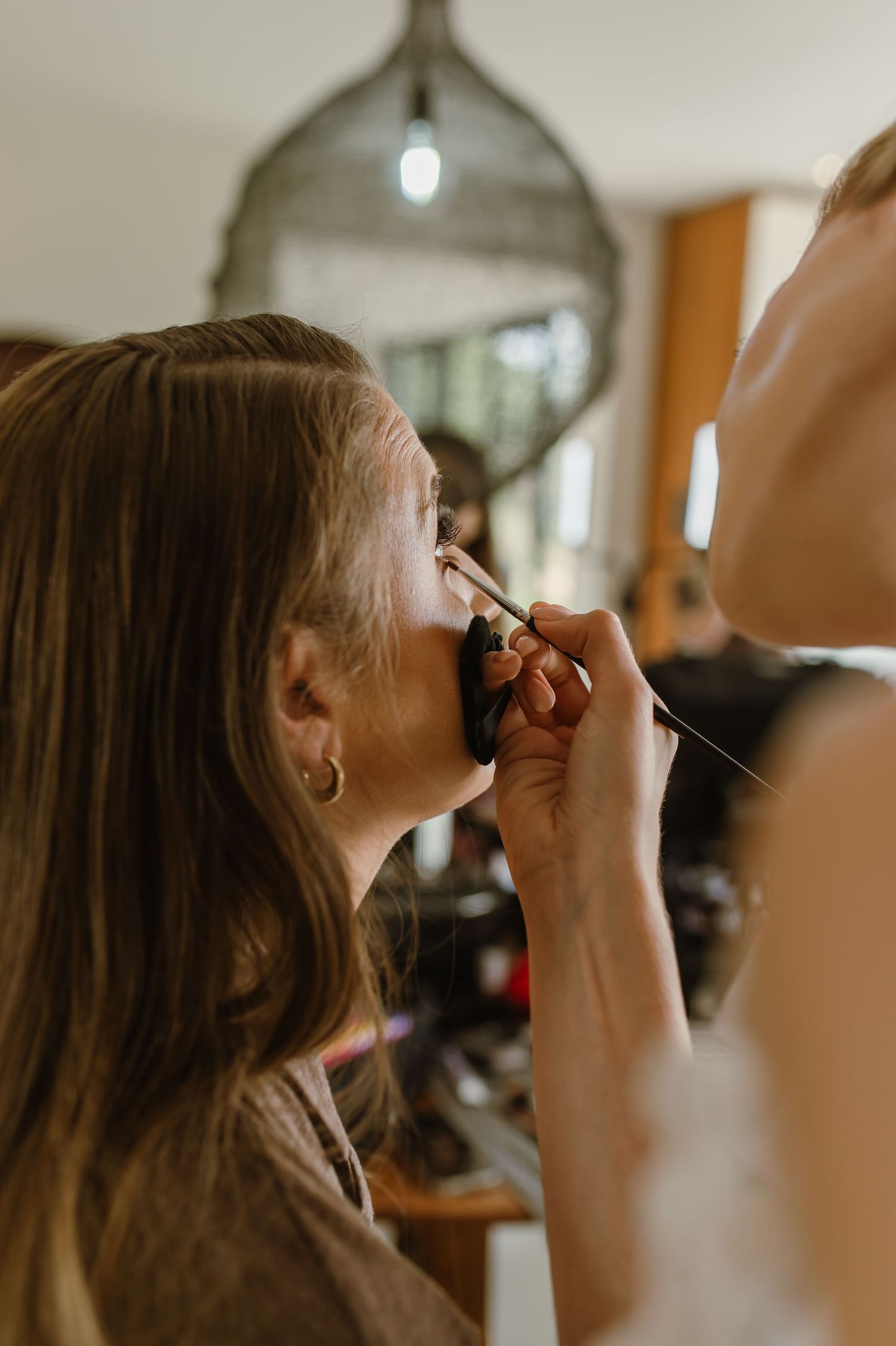 Makeup artist applying cosmetics to a client's face during a professional beauty session.