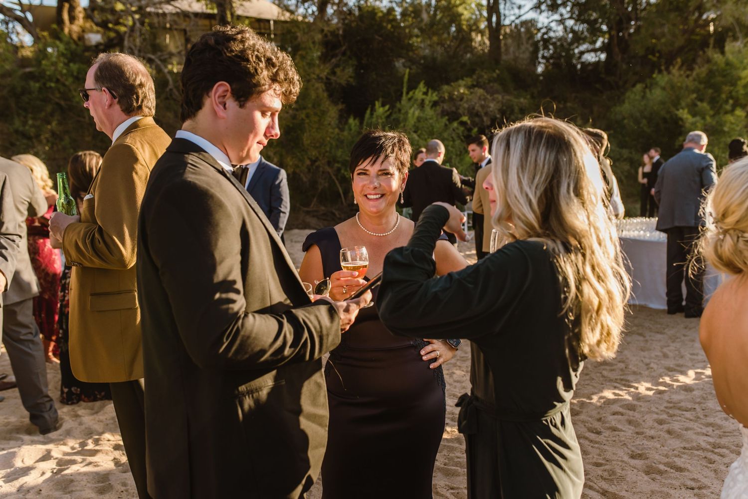 Evening beach gathering with guests socializing in casual attire.
